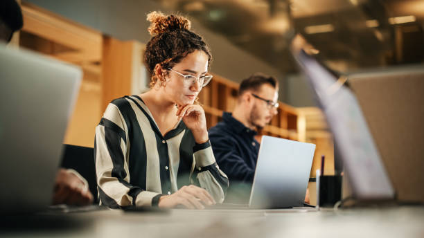 Jeune maman assise à son bureau pour la reprise de son travail après son congé maternité. Elle n'est pas heureuse